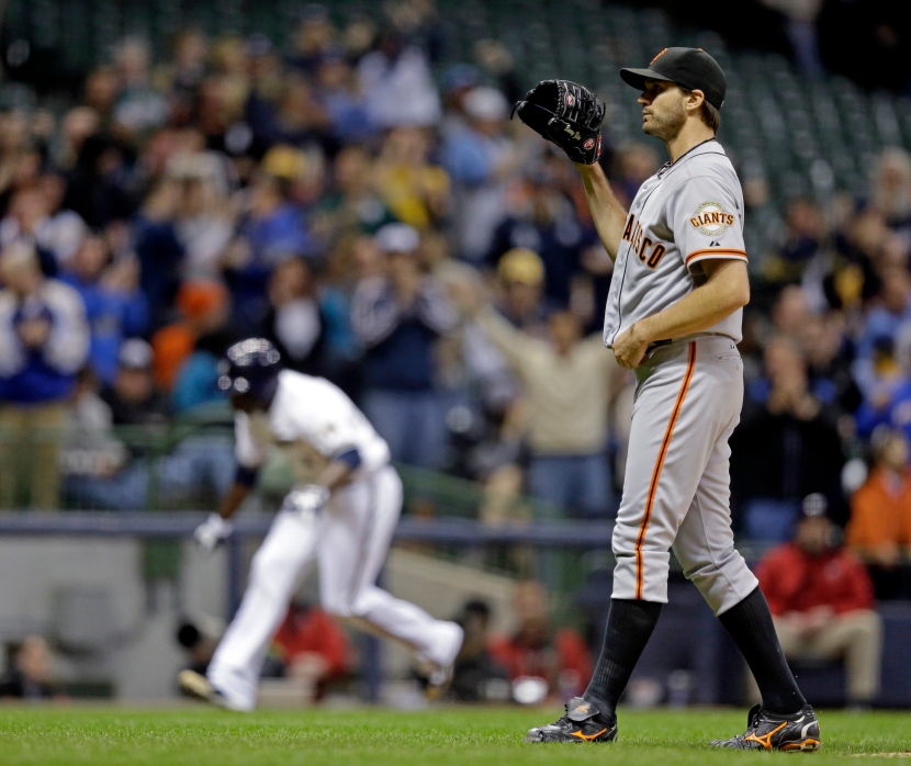San Francisco Giants starting pitcher Barry Zito waits for a new ball as Milwaukee Brewers' Yuniesky Betancourt rounds the bases after hitting a grand slam during the third inning of a baseball game Tuesday, April 16, 2013, in Milwaukee. (AP Photo/Morry Gash)