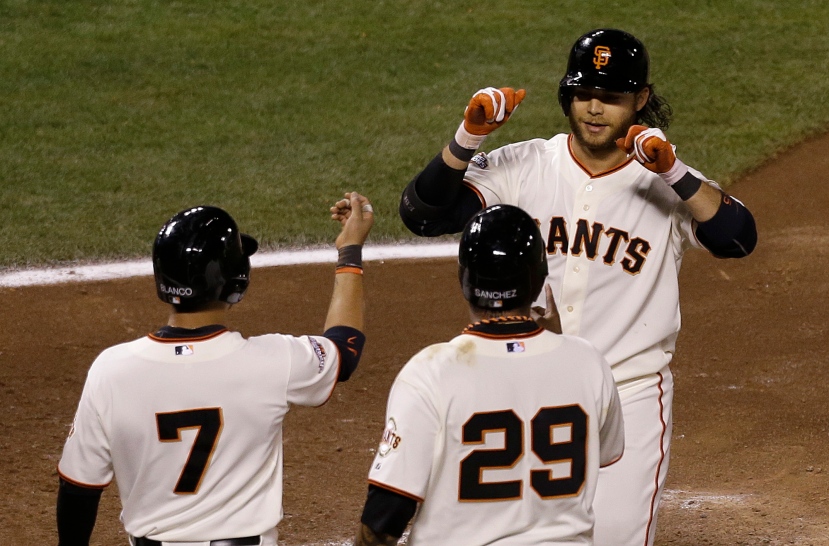 San Francisco Giants' Brandon Crawford, top, is congratulated after hitting a three-run home run off of Colorado Rockies pitcher Adam Ottavino to score Gregor Blanco (7) and Hector Sanchez (29) during the sixth inning of a baseball game in San Francisco, Tuesday, April 9, 2013. (AP Photo/Jeff Chiu)